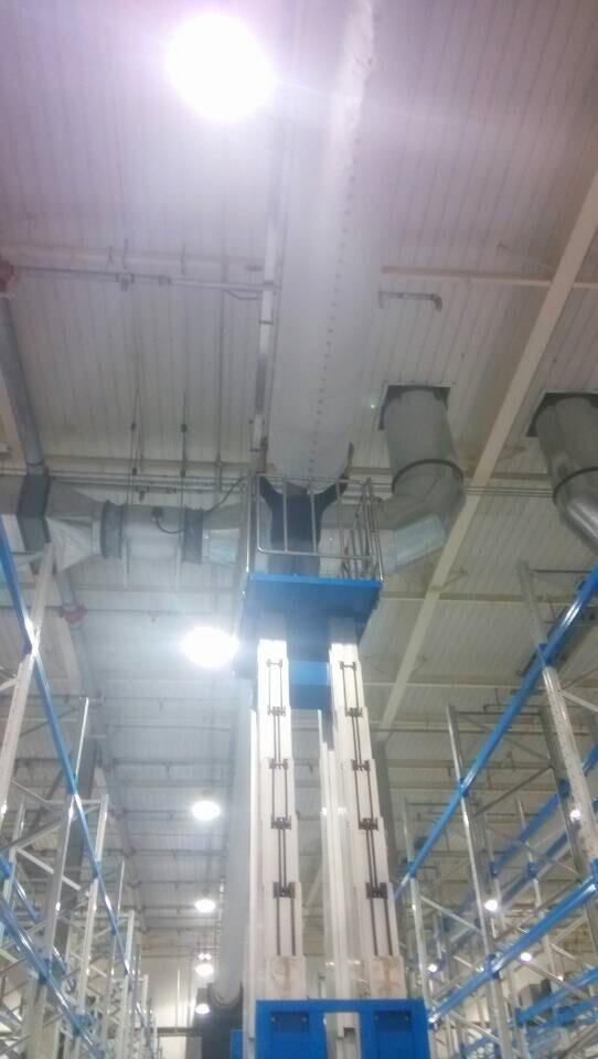 李工站在升降机上检查织物布风管